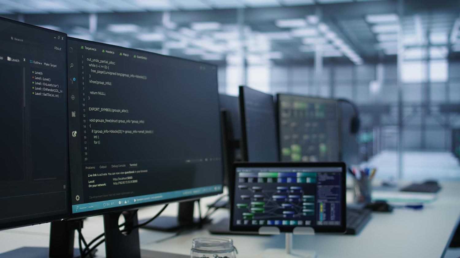 Developer workspace with code on screens